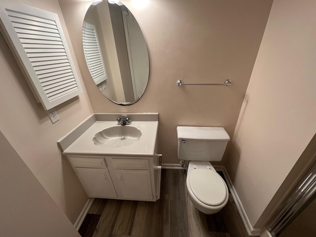 bathroom featuring vanity, wood finished floors, toilet, and baseboards