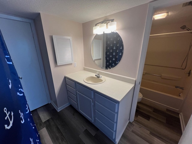 full bathroom with vanity, a textured ceiling, toilet, and wood finished floors