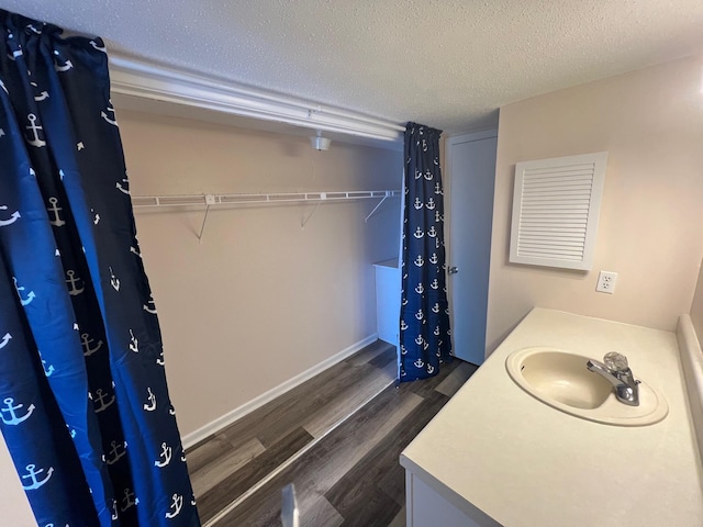 bathroom with vanity, a textured ceiling, and wood finished floors