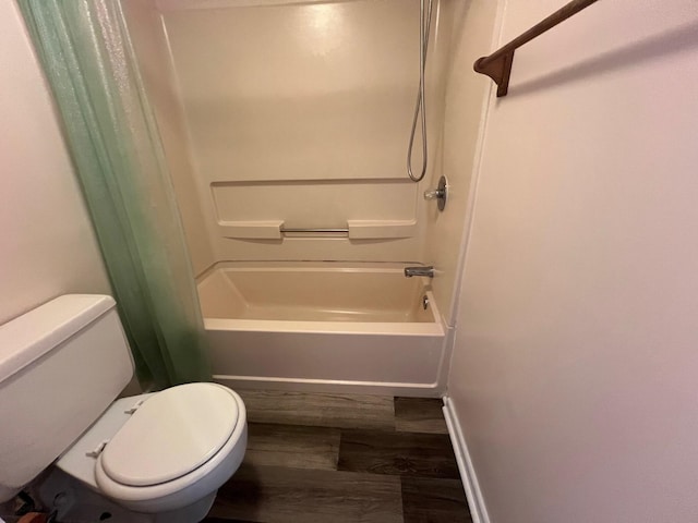 full bath featuring toilet, shower / tub combination, baseboards, and wood finished floors