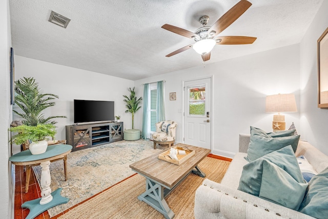 living room featuring a textured ceiling and ceiling fan