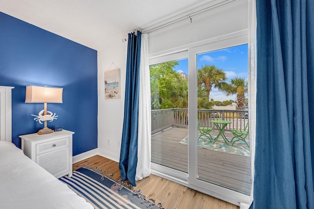 bedroom with access to outside and light hardwood / wood-style floors