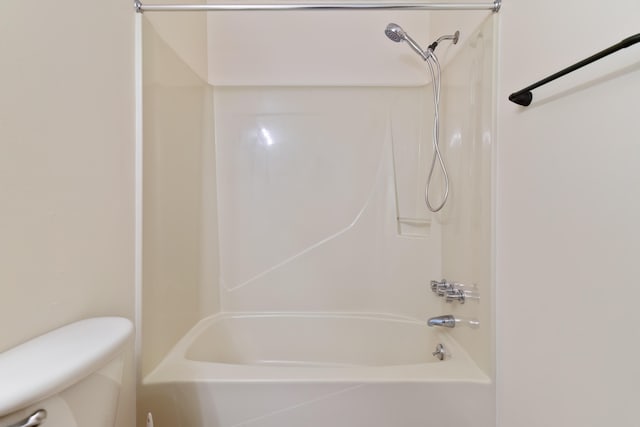 bathroom with washtub / shower combination and toilet