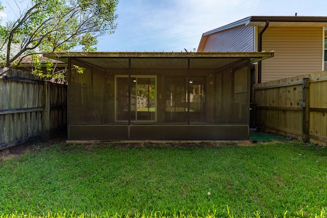 back of house featuring a yard and a sunroom