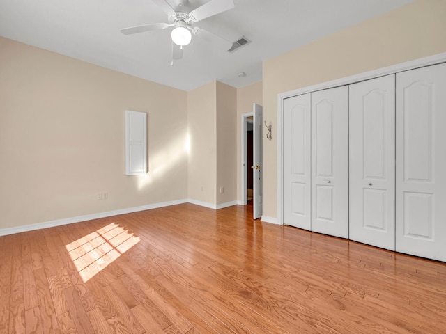 unfurnished bedroom with light wood-type flooring, a closet, and ceiling fan