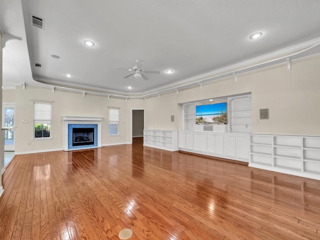 unfurnished living room featuring ceiling fan, light wood-type flooring, and crown molding