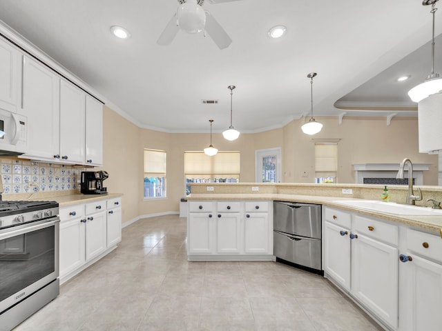 kitchen with decorative light fixtures, backsplash, stainless steel appliances, and sink