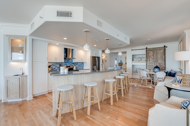 kitchen with a kitchen breakfast bar, white cabinetry, and a barn door