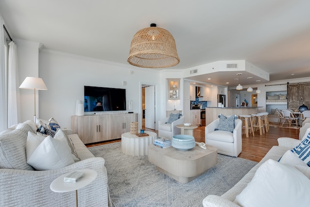 living room featuring crown molding and light hardwood / wood-style flooring