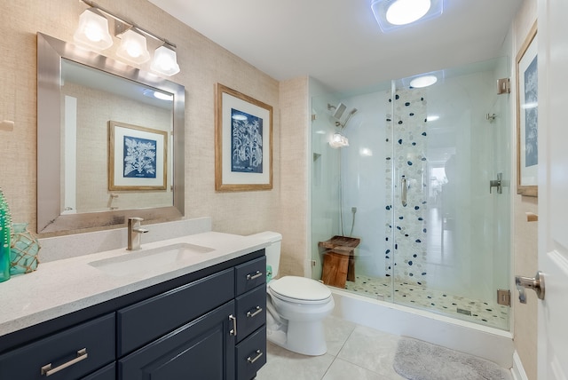 bathroom with tile patterned flooring, walk in shower, toilet, and vanity