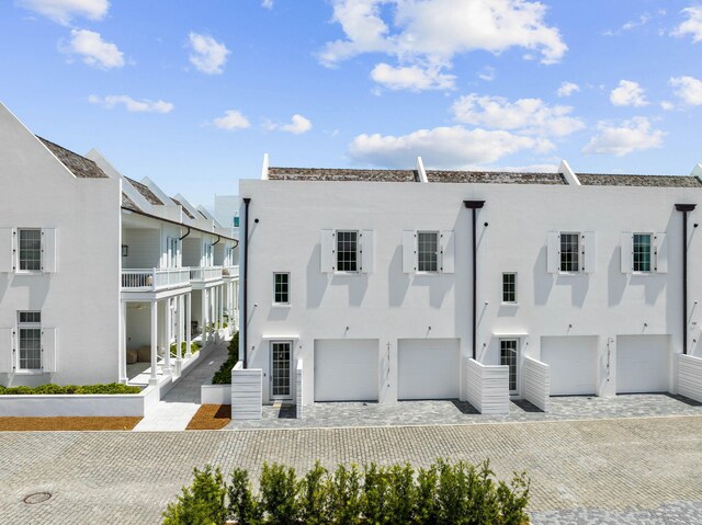 back of house featuring a balcony and a garage