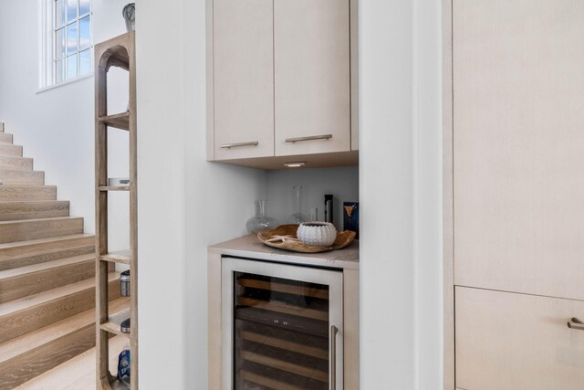 bar with beverage cooler and white cabinetry