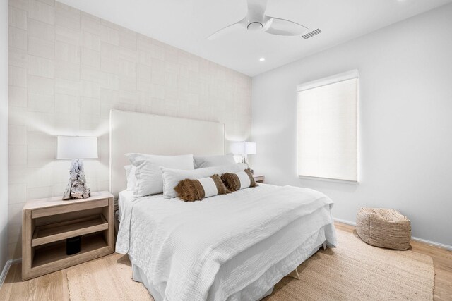 bedroom with light hardwood / wood-style flooring and ceiling fan