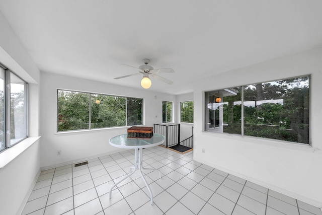 unfurnished sunroom with ceiling fan and a healthy amount of sunlight