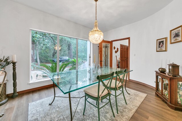 dining room with hardwood / wood-style floors and an inviting chandelier