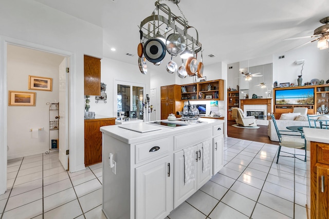 664 Woodland Bayou Dr, Santa Rosa Beach, FL 32459 - kitchen featuring light tile patterned floors, white cabinetry, ceiling fan, a glass covered fireplace, and light countertops