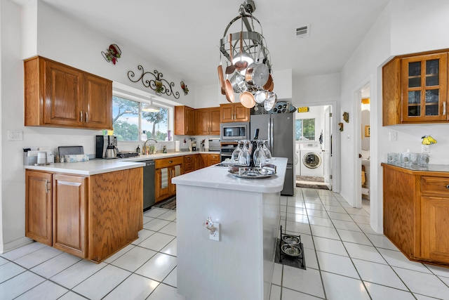 664 Woodland Bayou Dr, Santa Rosa Beach, FL 32459 - kitchen with brown cabinetry, light countertops, washer / dryer, and appliances with stainless steel finishes