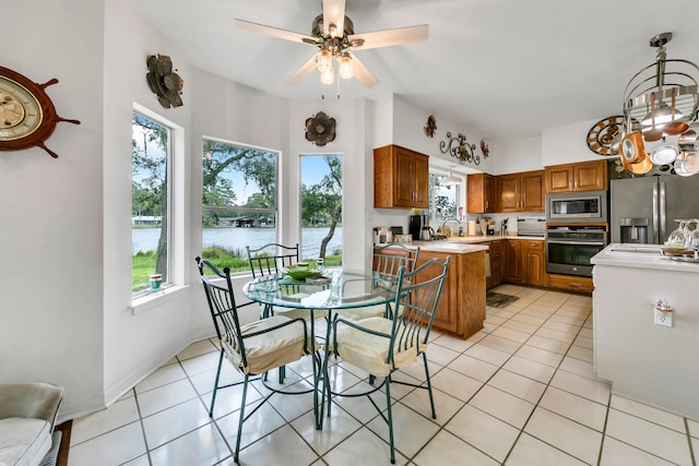 kitchen with plenty of natural light, a water view, light tile patterned flooring, and appliances with stainless steel finishes