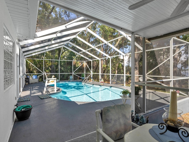 view of swimming pool featuring a patio area and glass enclosure