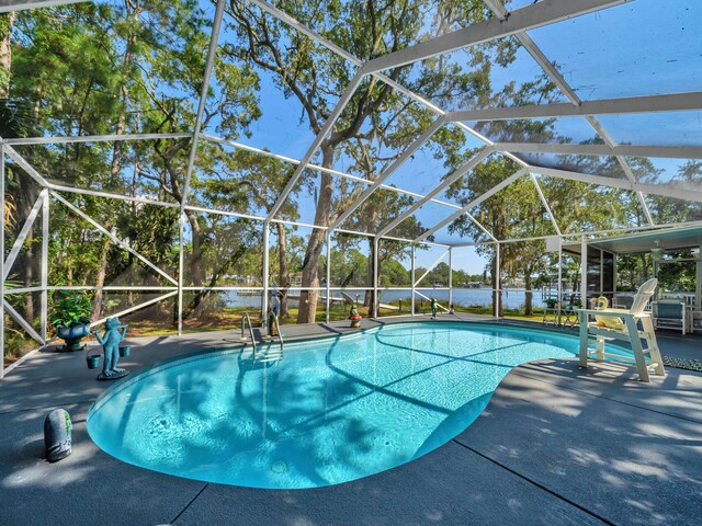 view of pool featuring glass enclosure and a patio area