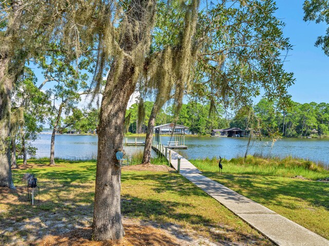 dock area with a yard and a water view