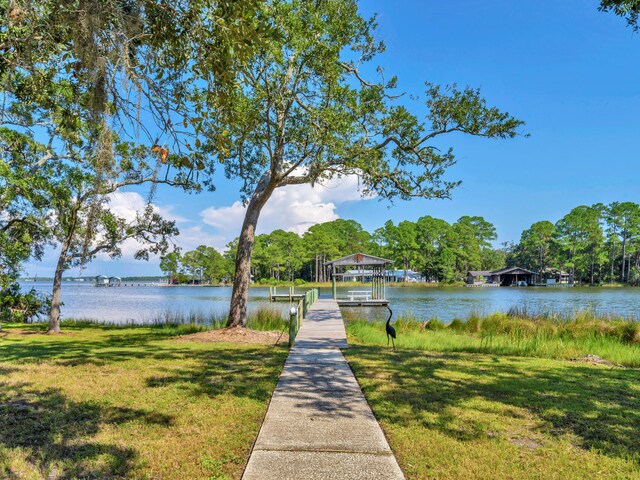 view of dock featuring a water view and a yard