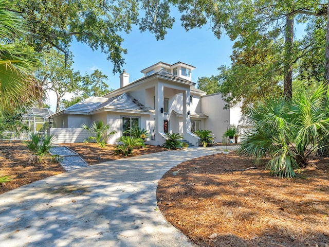 664 Woodland Bayou Dr, Santa Rosa Beach, FL 32459 - view of front of property with stucco siding, a chimney, and curved driveway