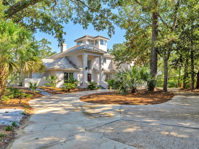 664 Woodland Bayou Dr, Santa Rosa Beach, FL 32459 - view of front of property with curved driveway, stucco siding, and a chimney