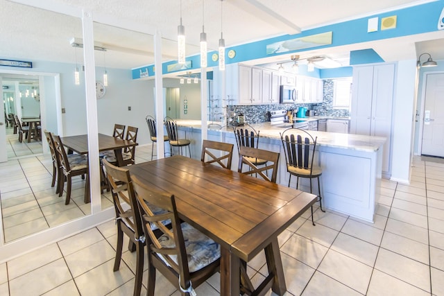 dining room featuring light tile patterned floors, french doors, and a textured ceiling