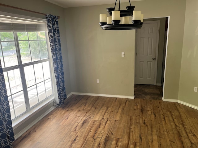 unfurnished dining area featuring wood-type flooring and a chandelier