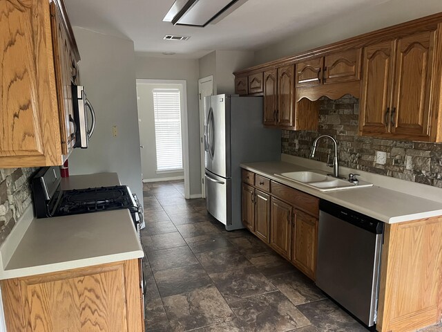 kitchen with backsplash, stainless steel appliances, and sink