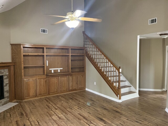 unfurnished living room with high vaulted ceiling, ceiling fan, and wood-type flooring