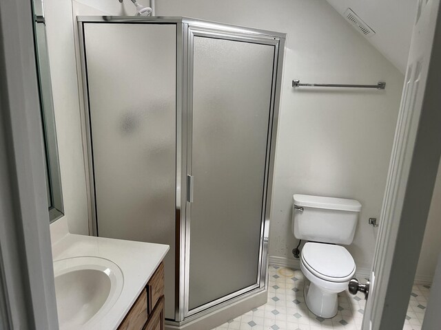 bathroom featuring vaulted ceiling, toilet, a shower with door, and vanity