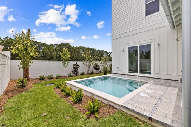 view of swimming pool with a patio area and a yard