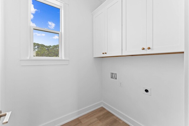 washroom with hookup for a washing machine, cabinets, hookup for an electric dryer, and light hardwood / wood-style floors