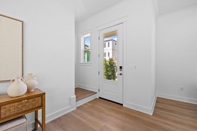 foyer entrance with crown molding and light hardwood / wood-style flooring