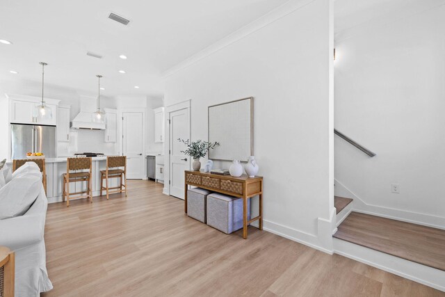 living room featuring ornamental molding and light hardwood / wood-style flooring