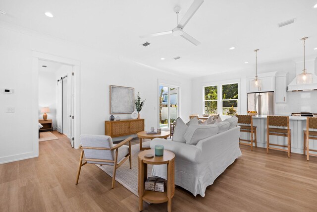 living room with light wood-type flooring and ceiling fan