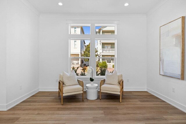 living area featuring crown molding and wood-type flooring