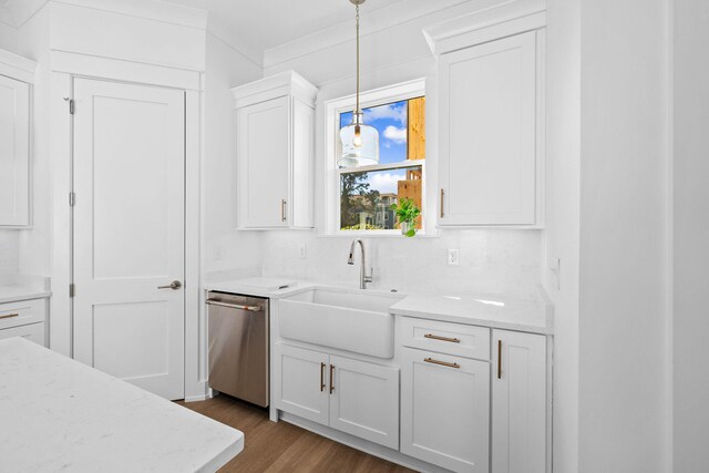 kitchen featuring tasteful backsplash, decorative light fixtures, wood-type flooring, sink, and stainless steel dishwasher