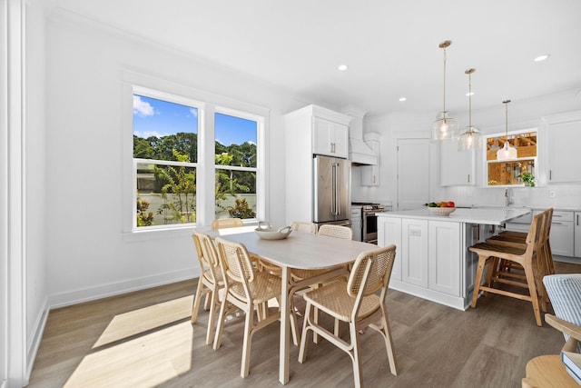 dining space with crown molding, plenty of natural light, and wood-type flooring