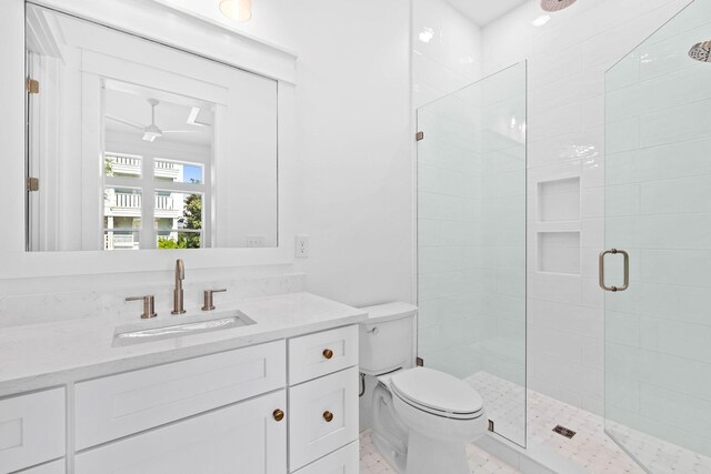 bathroom featuring vanity, toilet, and a shower with door