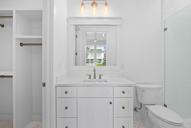 bathroom featuring tiled shower, vanity, and toilet