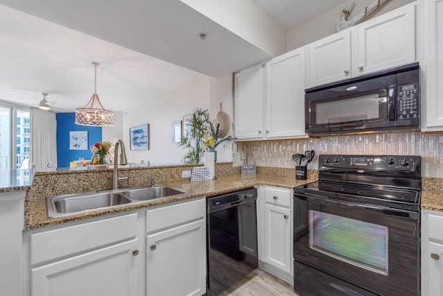 kitchen with black appliances, white cabinetry, sink, and light stone countertops