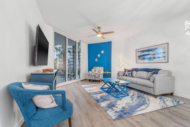 living room featuring light hardwood / wood-style flooring, ceiling fan, and floor to ceiling windows