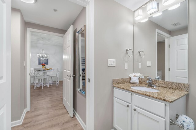 bathroom featuring vanity, a chandelier, and hardwood / wood-style floors