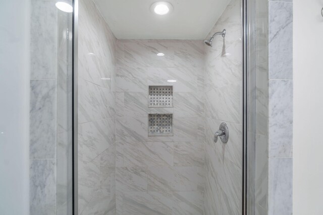 bathroom featuring a shower with door