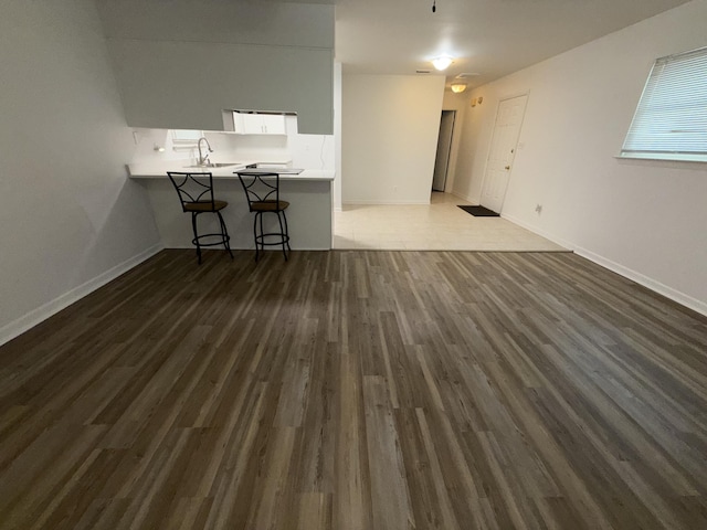 4 3rd Ave, Shalimar, FL 32579 - unfurnished living room featuring a sink, dark wood-style flooring, and baseboards