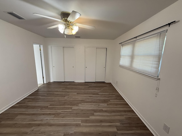 4 3rd Ave, Shalimar, FL 32579 - unfurnished bedroom featuring baseboards, dark wood-style floors, visible vents, and two closets