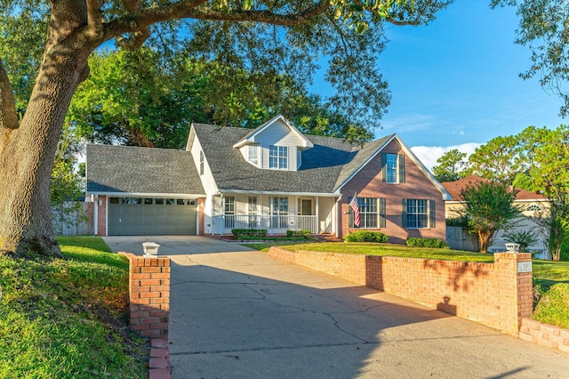 cape cod house featuring roof with shingles, concrete driveway, covered porch, fence, and a garage